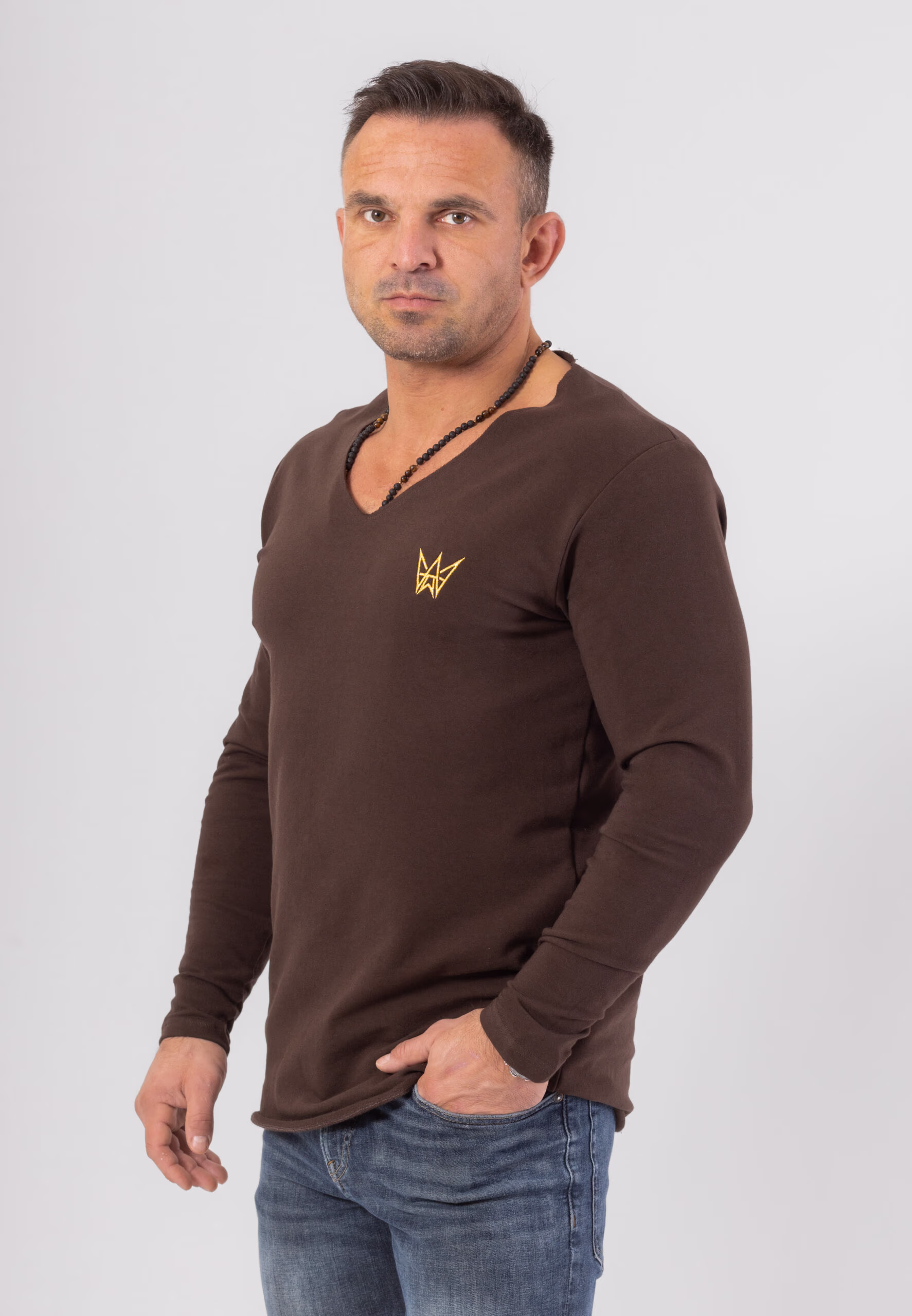 Koszulka z długim rękawem w kolorze czekoladowym z haftowaną koroną w kolorze złotym.