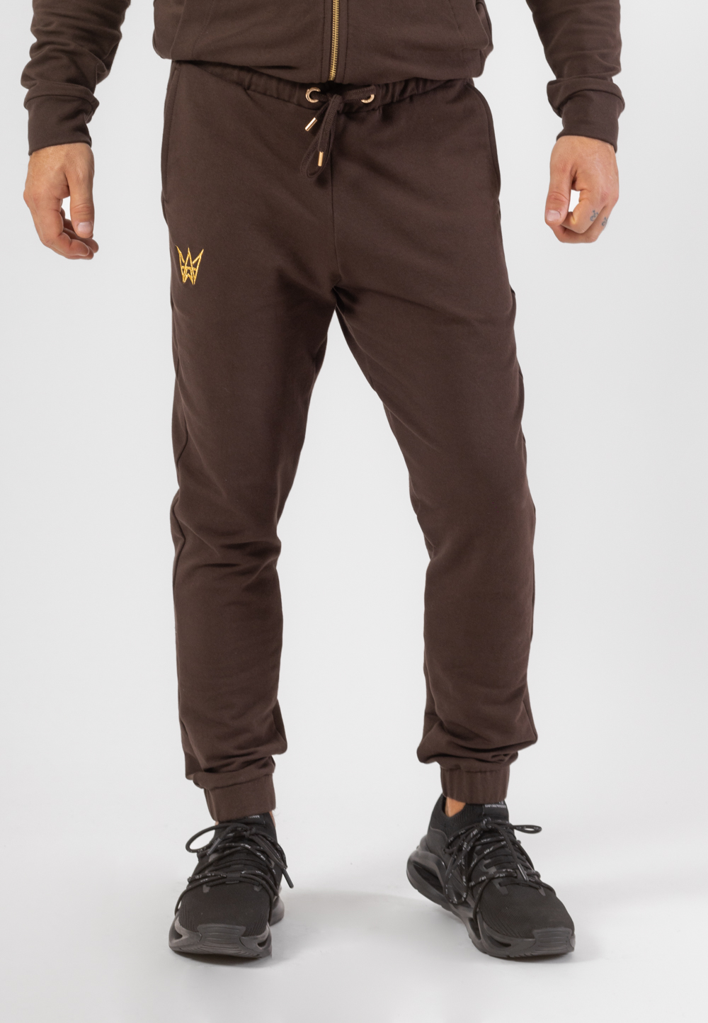 Komplet dresowy składający się z bluzy z golfem rozpinanej na zamek i długich spodni w kolorze czekoladowym z haftowaną koroną w kolorze złotym.