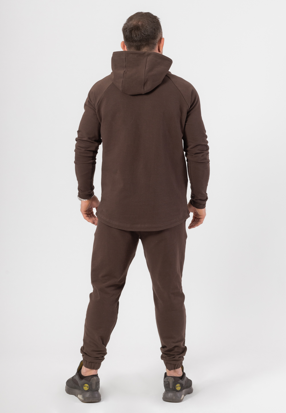 Komplet dresowy składający się z bluzy z kapturem i długich spodni w kolorze czekoladowym z haftowaną koroną w kolorze złotym.