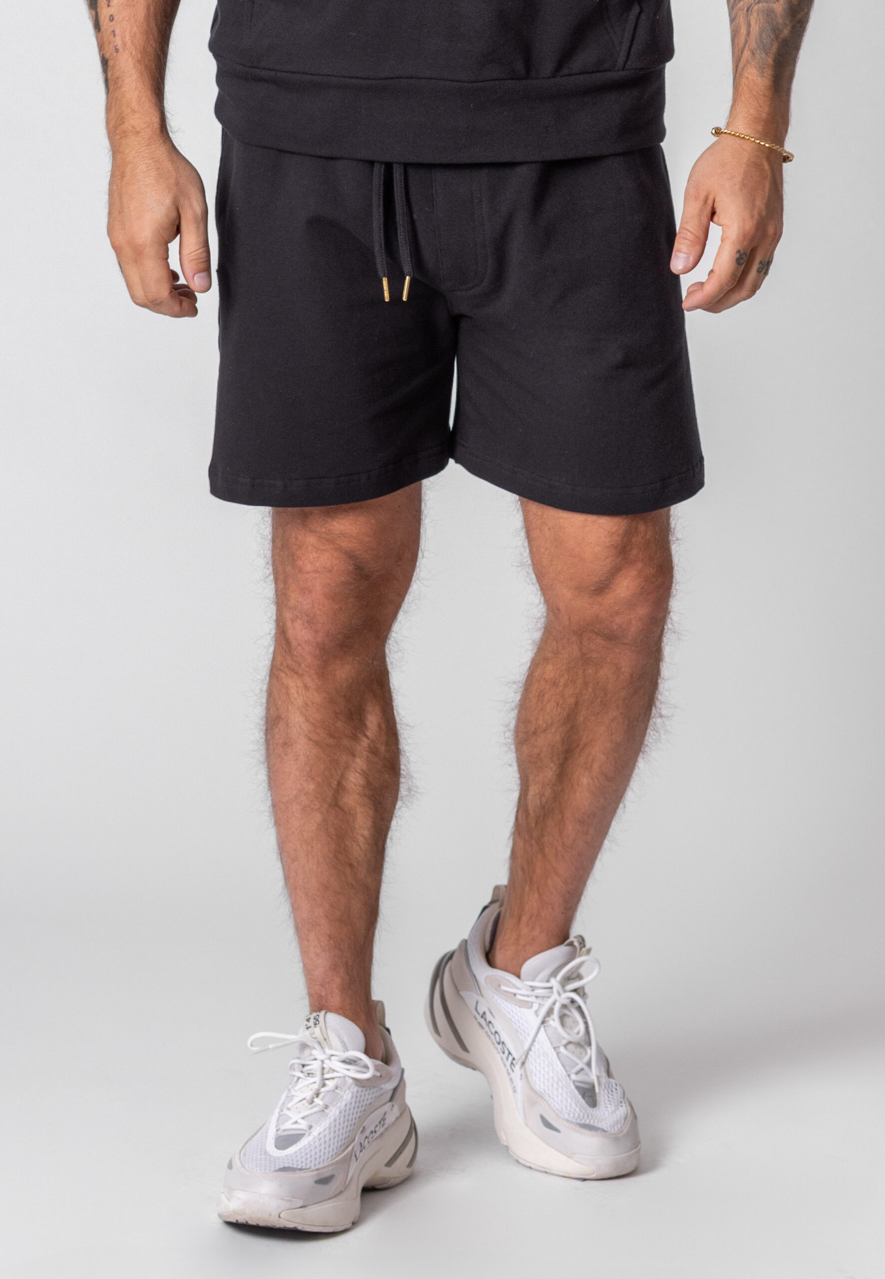 Krótkie Spodenki Oversize Czarne - Korona Mosiądz 1 Krótkie spodenki Oversize w kolorze czarnym z koroną z mosiądzu.